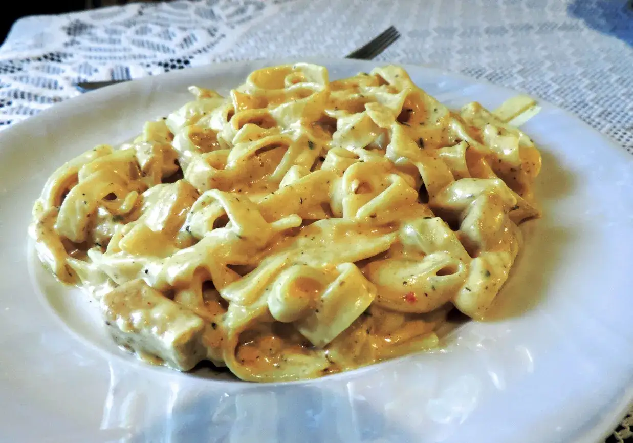 Tagliatelle z kurczakiem w sosie śmietanowym, bogato polane kremowym sosem, z kawałkami kurczaka.