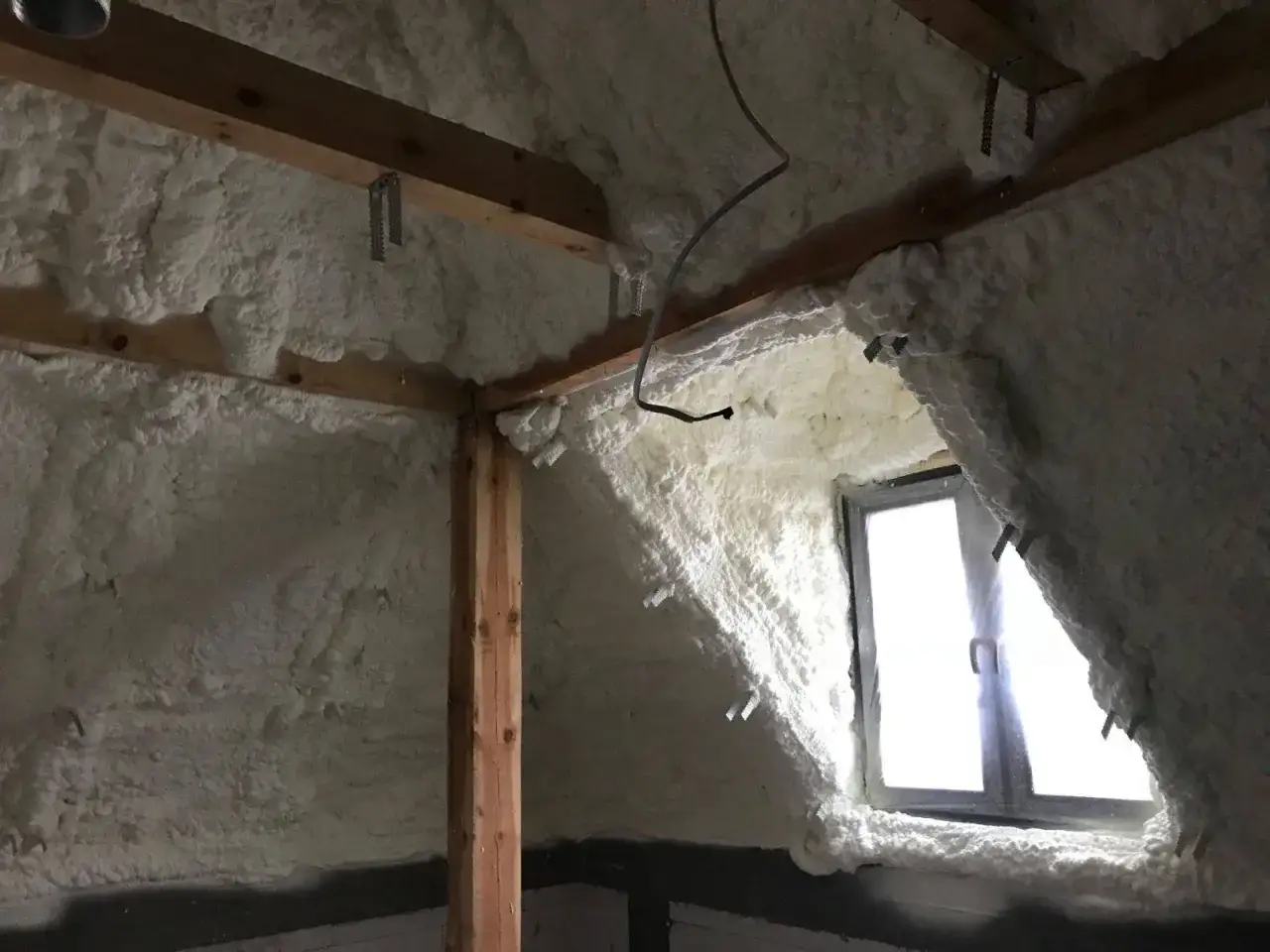 Piana PUR szczelnie otula drewnianą konstrukcję poddasza, tworząc izolację lepszą niż wełna.