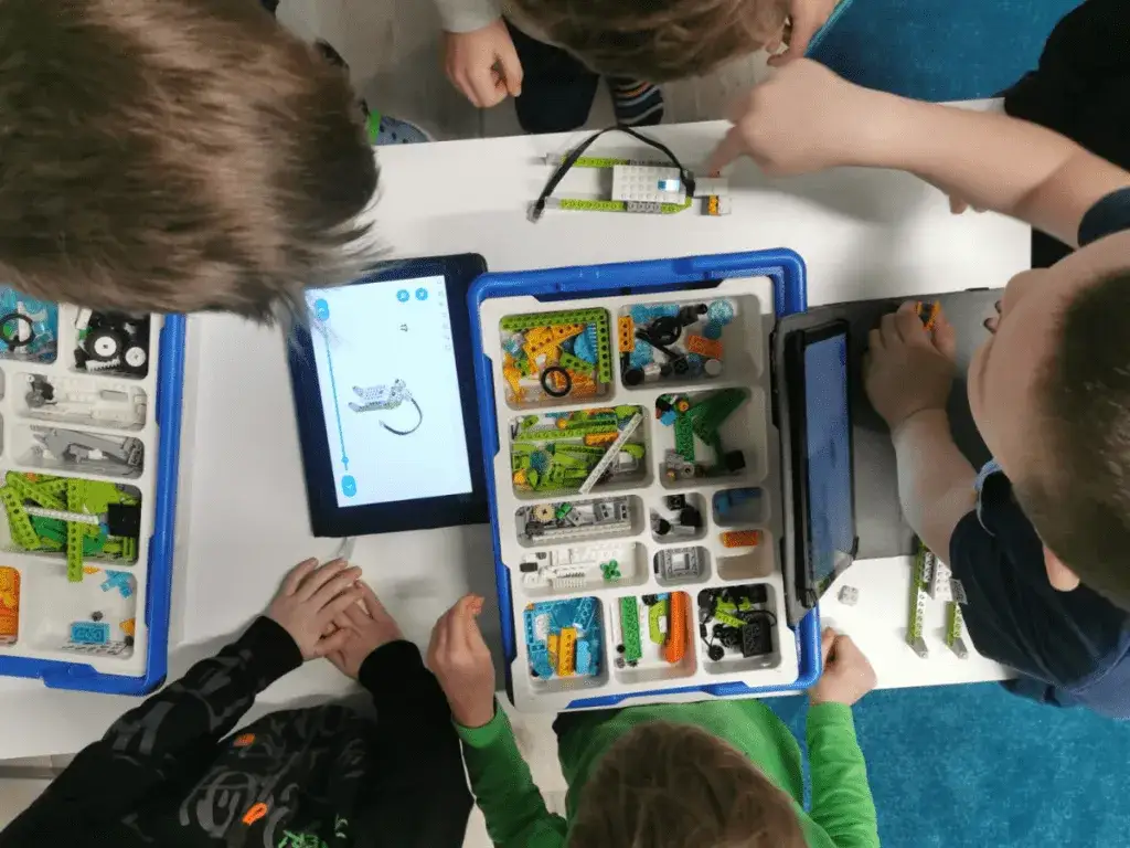 dzieci na zajęciach z robotyki budujące roboty z klock&oacute;w LEGO