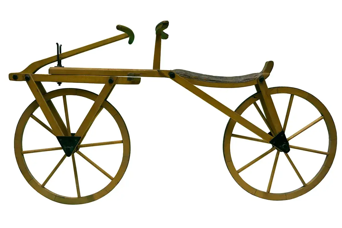 Drewniany pojazd z dwoma kołami, siodełkiem i kierownicą. To prototyp, który zapoczątkował historię, kto wynalazł pierwszy rower.