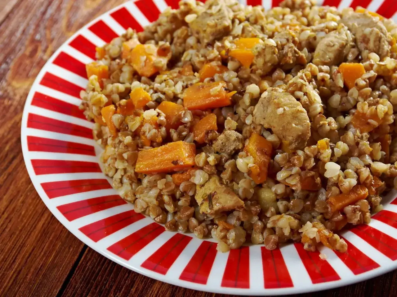 Pyszna kasza gryczana z kawałkami mięsa i marchewki, idealna jako dodatek do gulaszu.