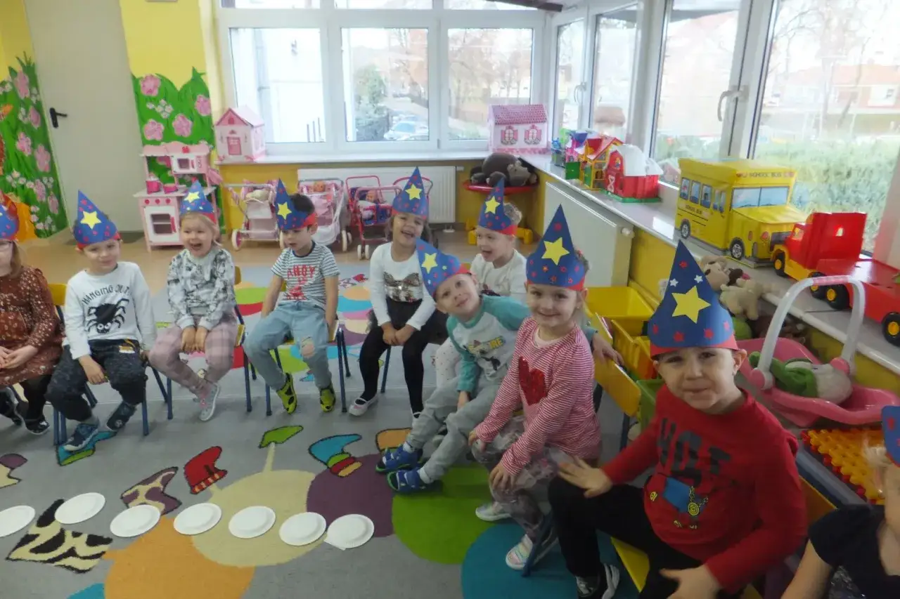 Dzieci w przedszkolu świętują andrzejki w czarodziejskich czapkach. Wesołe buzie i kolorowe stroje to świetne pomysły na zabawę!