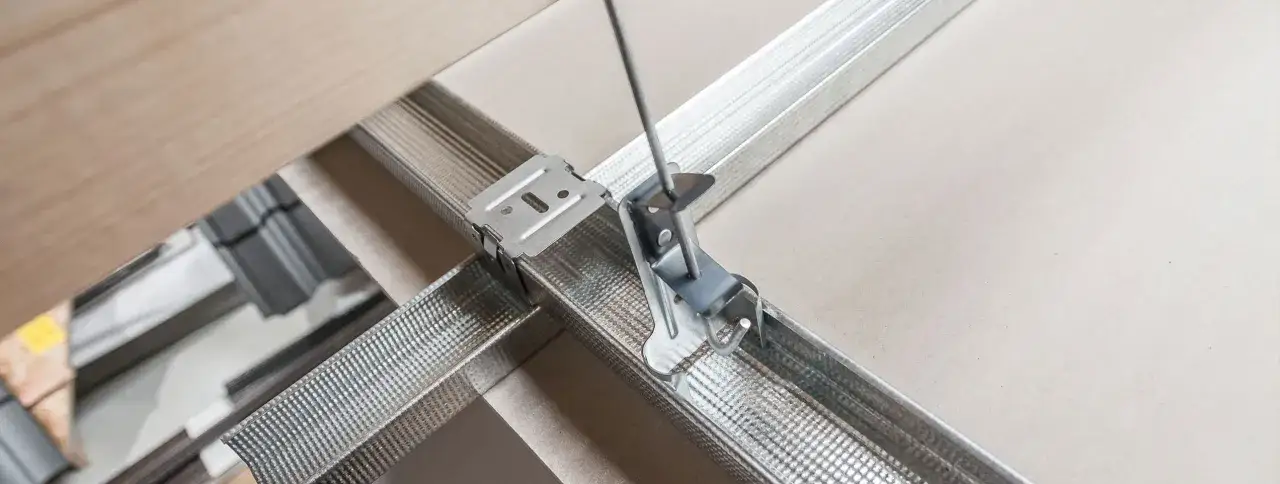 Metalowy profil j do gk, tworzący konstrukcję sufitu podwieszanego. Widać mocowanie do profila.