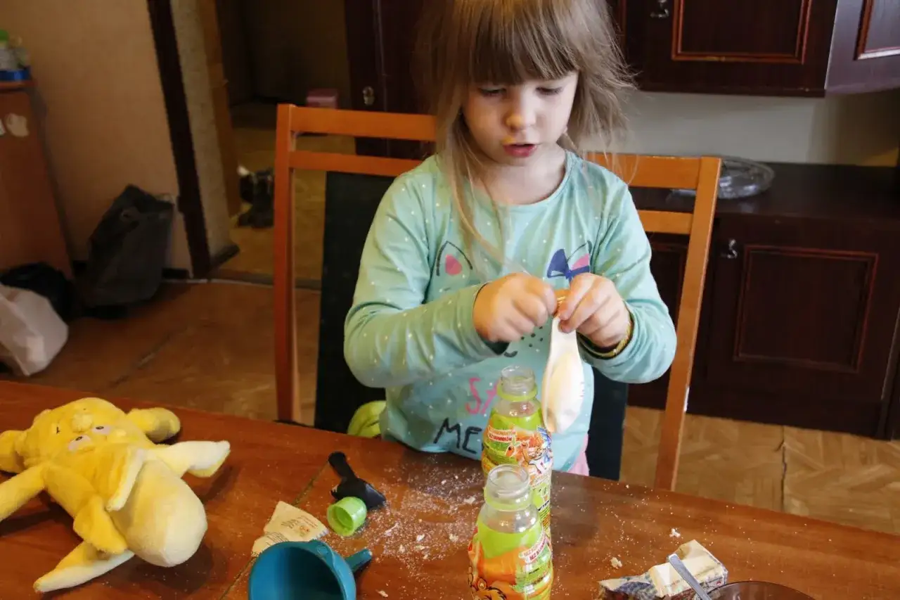 Dziecko z rodzicem robiące eksperyment z drożdżami i balonem