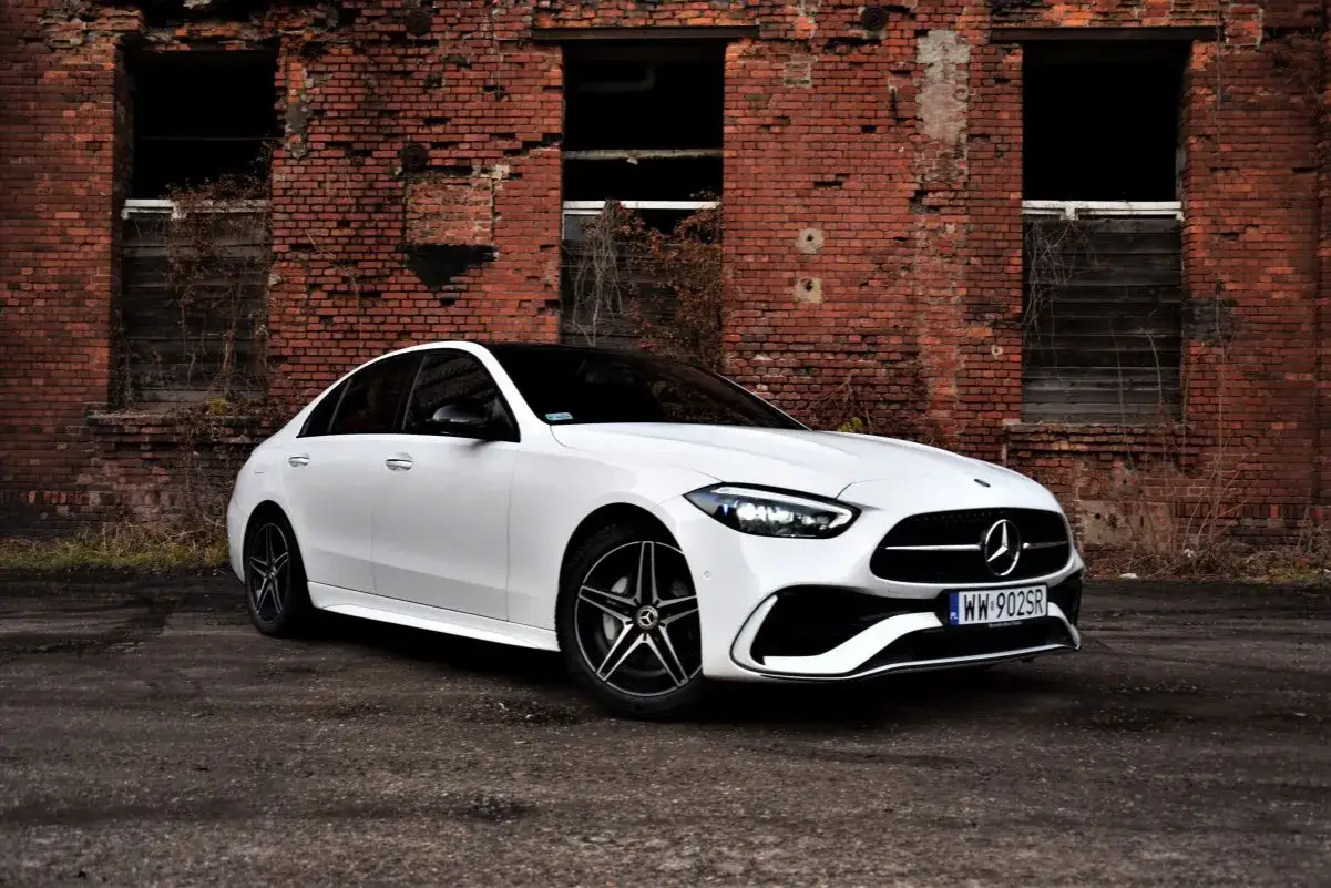 Biały Mercedes Klasy C na tle ceglanej ściany. Poznaj jego dane techniczne i poczuj moc.