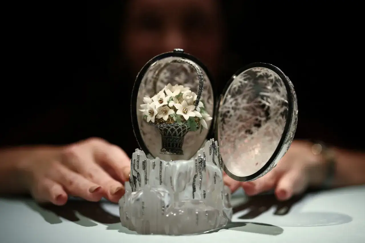 Otwarta szkatułka z miniaturowym bukietem kwiat&oacute;w w koszyku, ozdobiona diamentami. To arcydzieło, jedno z jaj Faberge, zachwyca precyzją wykonania.