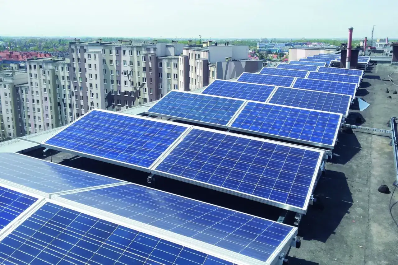 Panele fotowoltaiczne na dachu bloku mieszkalnego. Bank Gospodarstwa Krajowego wspiera takie inwestycje w odnawialne źródła energii.
