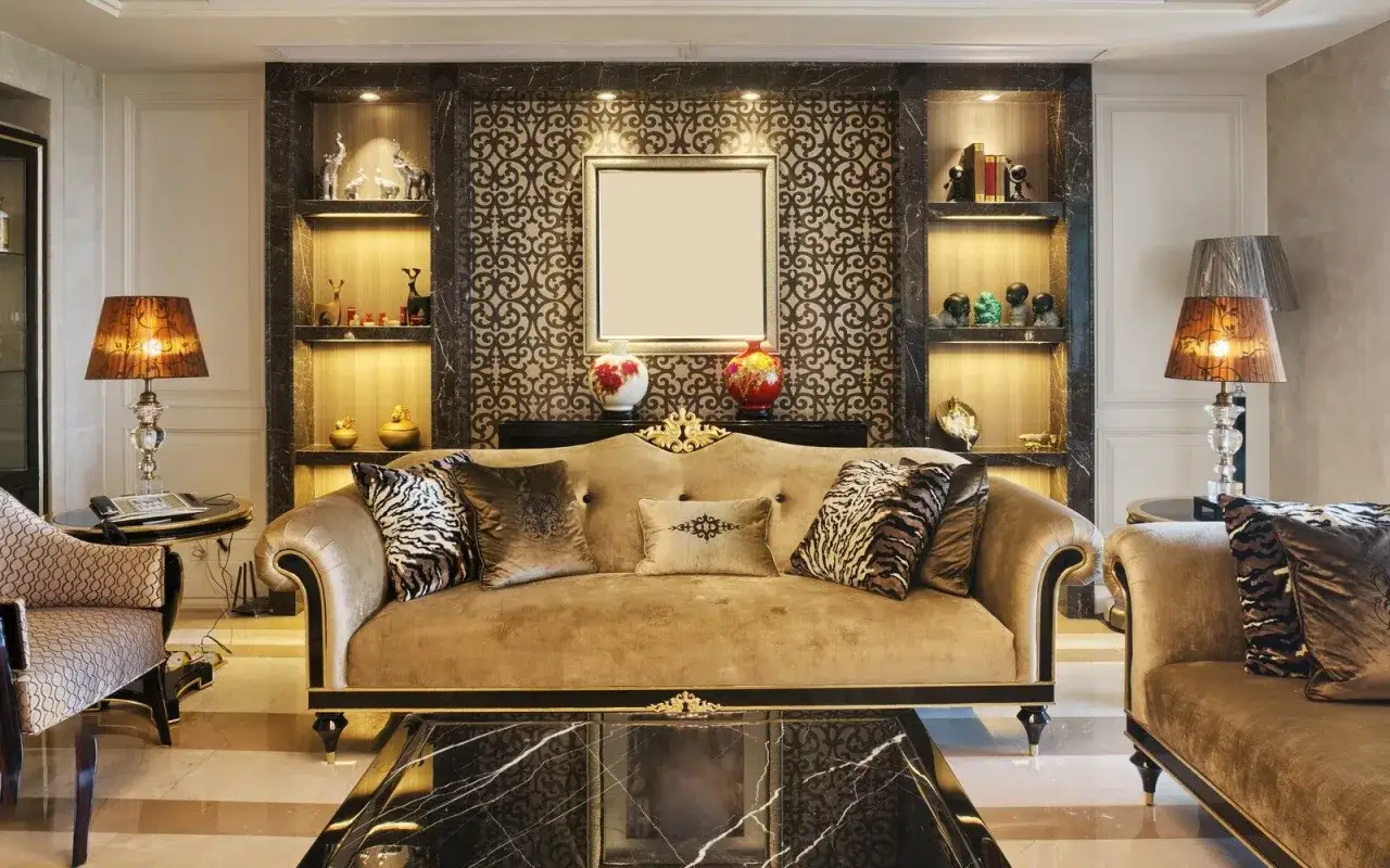 Elegancki salon w stylu **dom art deco**. Złota sofa, wzorzyste poduszki, ozdobne p&oacute;łki z bibelotami i stylowe lampy tworzą luksusową atmosferę.