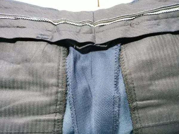 tylny szew w spodniach garniturowych z zapasem materiału