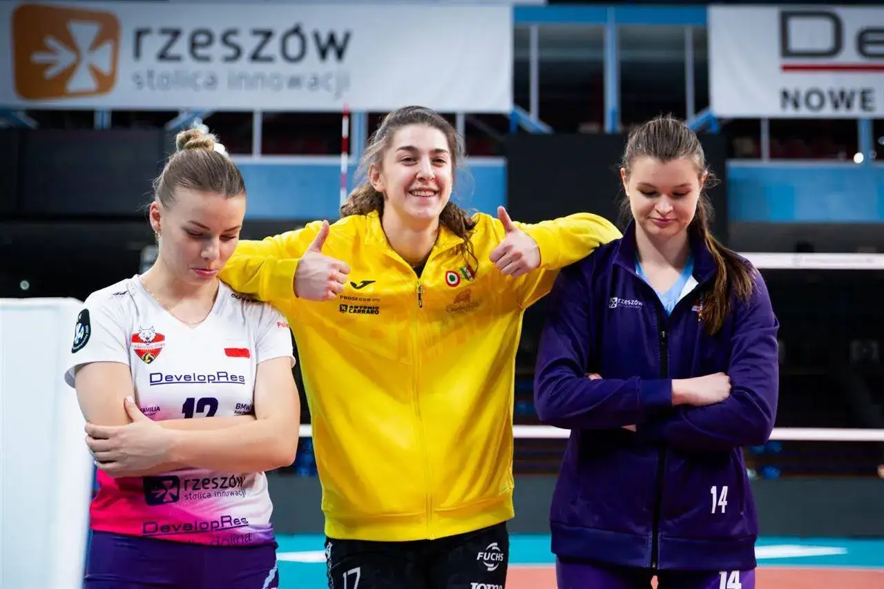 Trzy siatkarki po meczu Ligi Mistrzyń. Jedna w żółtej bluzie z kciukami w górze, dwie pozostałe zamyślone.