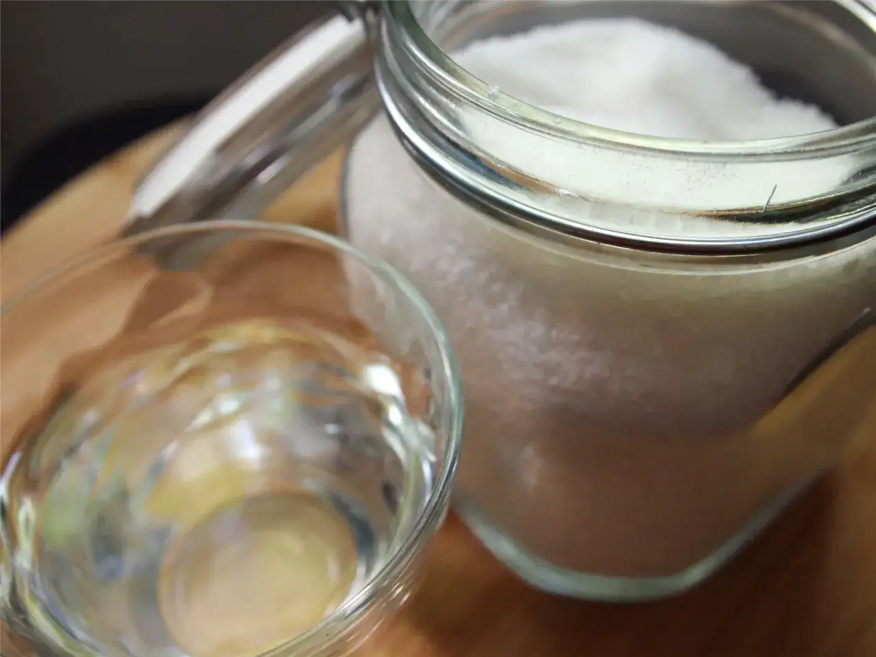 Słoik z cukrem i szklanka z wodą – składniki do przygotowania domowego syropu cukrowego (simple syrup) krok po kroku.