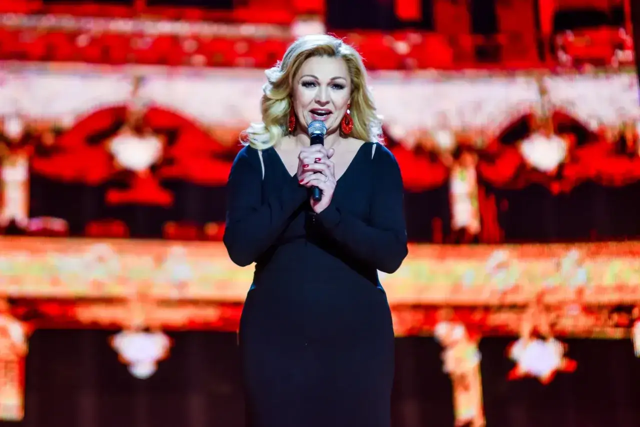 Małgorzata Walewska, wokalistka, śpiewa na scenie. Jej wiek nie jest widoczny, ale energia sceniczna jest ogromna.