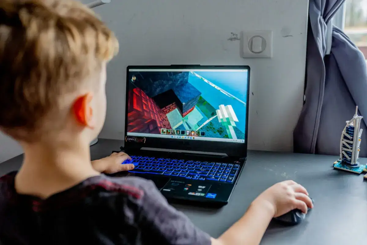 Chłopiec gra w Minecrafta na laptopie, ucząc się matematyki przez zabawę.