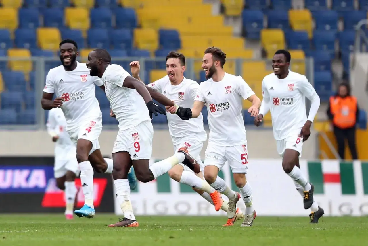 Radosni piłkarze ze Stambułu w białych strojach świętują bramkę na boisku.