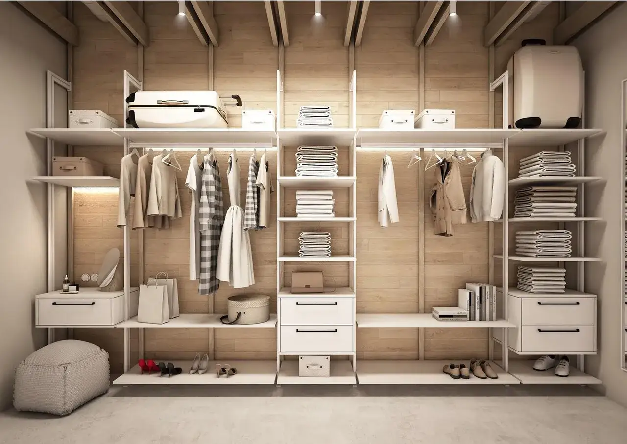 Nowoczesna garderoba w sypialni za ścianką. Ubrania na wieszakach, stosy ręczników, walizki i buty czekają na właścicieli.