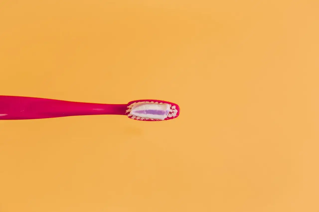 R&oacute;żowa szczoteczka z pastą do zęb&oacute;w, zawierającą fluorek sodu, gotowa do walki z pr&oacute;chnicą. Fluor to klucz do zdrowych zęb&oacute;w.