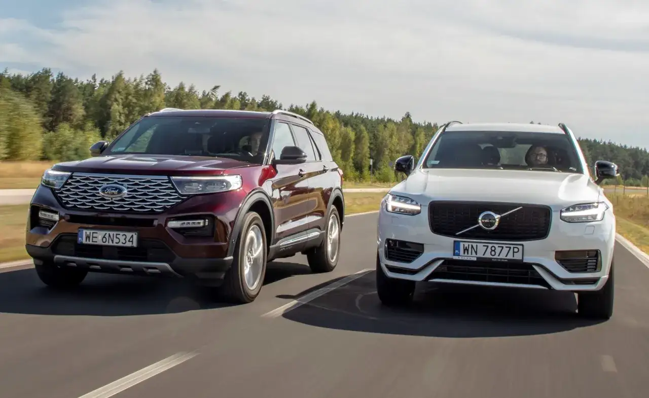 Porównanie Forda Explorera i białego Volvo XC90. Kierowca Volvo XC90 zastanawia się nad volvo xc90 spalanie.