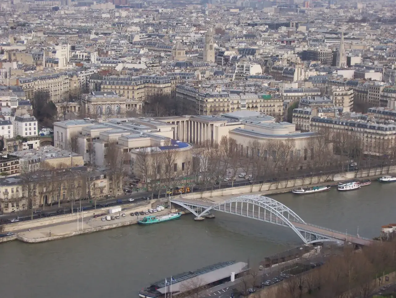 Widok na dachy Paryża, rzekę Sekwanę i most. W oddali widać zabudowania 16. dzielnicy Paryża.