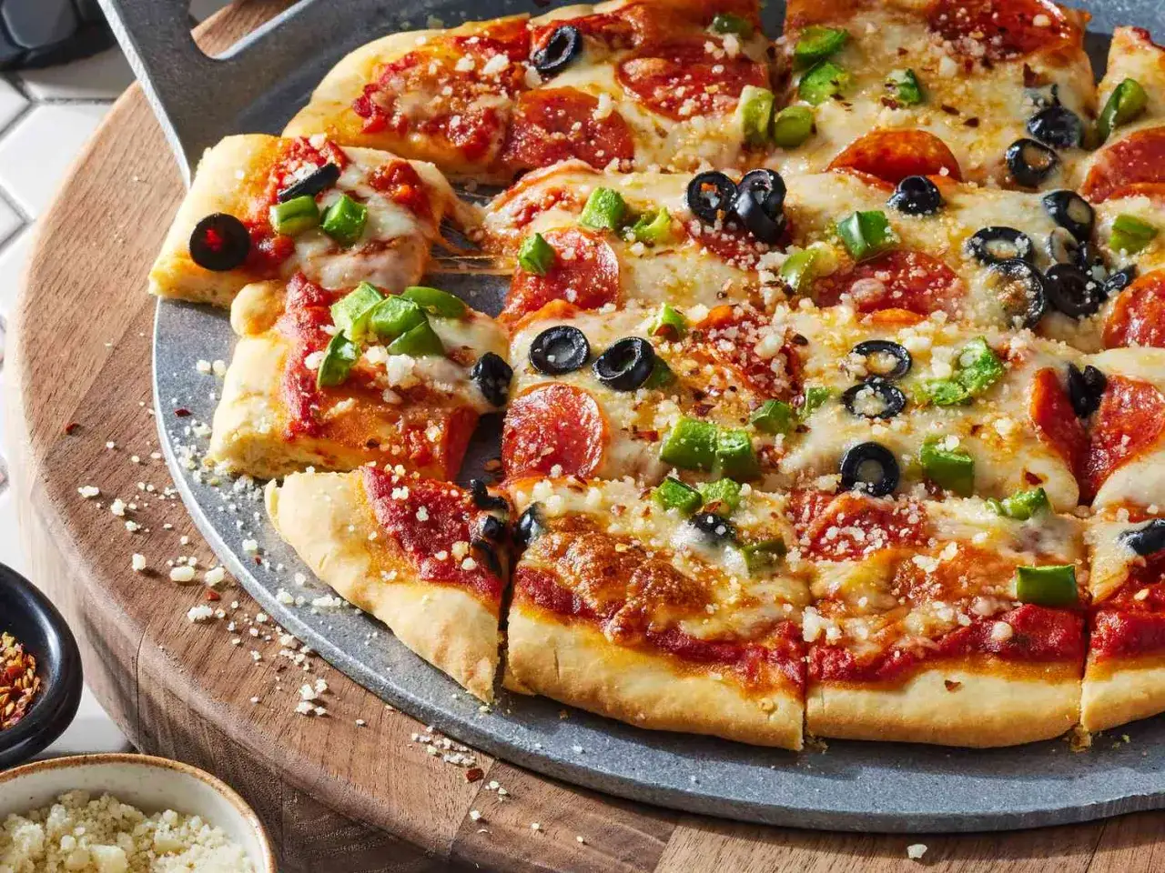 Pyszna pizza bez drożdży z pepperoni, oliwkami i papryką, posypana parmezanem. Idealna na szybki obiad.