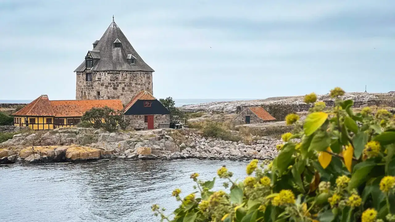 Kamienna wieża i zabudowania na skalistej duńskiej wyspie na Bałtyku.