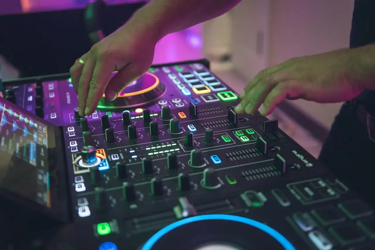 DJ grający na imprezie z konsolą i oświetleniem
