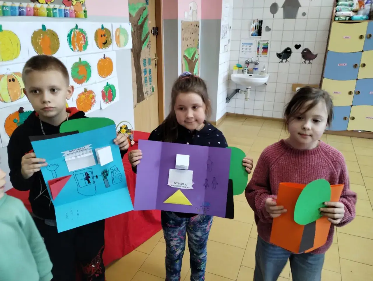 Dzieci prezentują swoje prace plastyczne, kt&oacute;re są przykładami cel&oacute;w edukacyjnych.