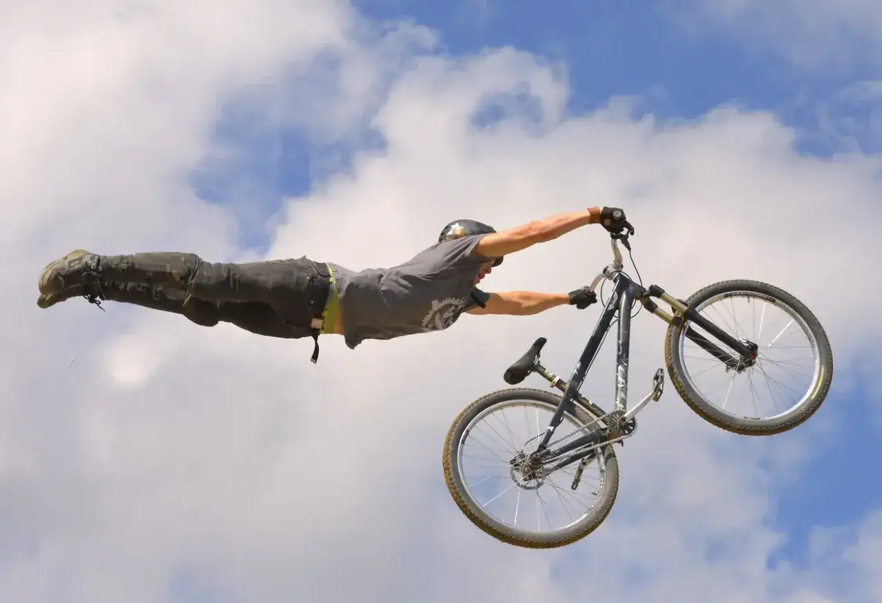 Kolarz wykonuje ewolucję w powietrzu na rowerze, przypominając superbohatera. To niesamowity rower na hopy!