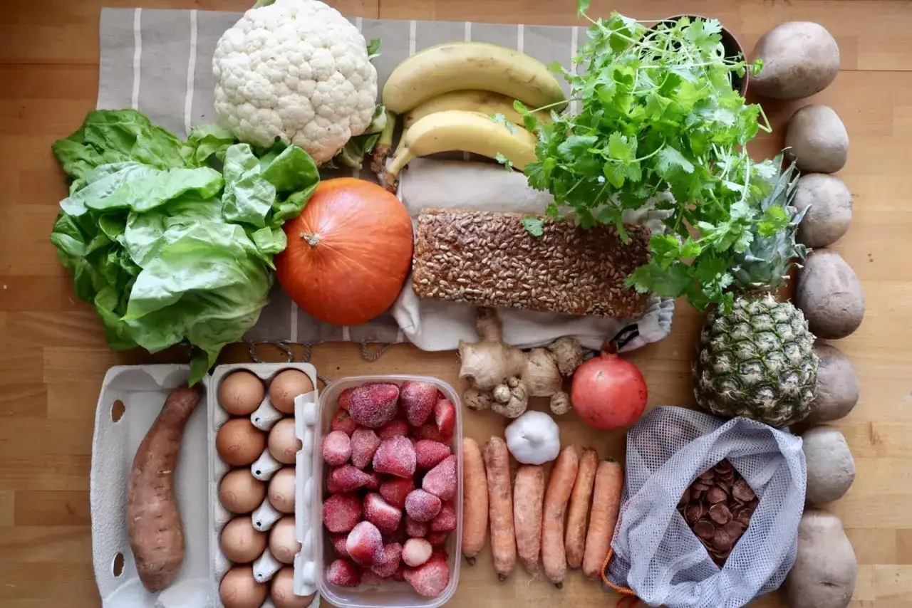 Jajka w wytłoczce, obok warzyw i owoc&oacute;w. Czy jajka są wegetariańskie? To pytanie często zadają osoby na diecie roślinnej.