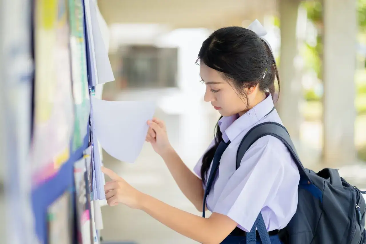 Młodzież przed liceum z plecakami, oczekiwanie na wyniki rekrutacji