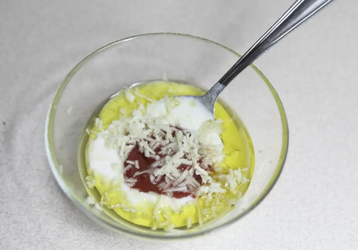 Mieszanka składników na oryginalny sos do kebaba: jogurt, ketchup, czosnek i olej.