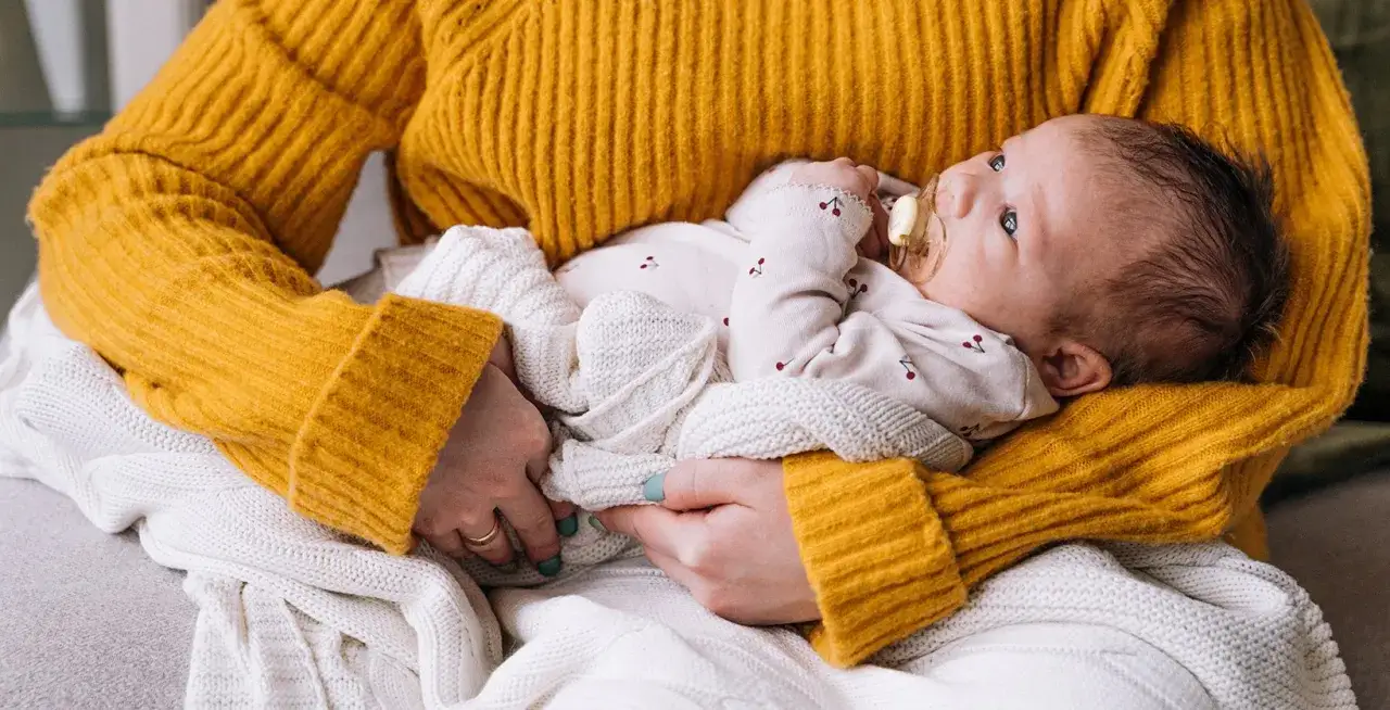 Marudzące niemowlę na rękach rodzica