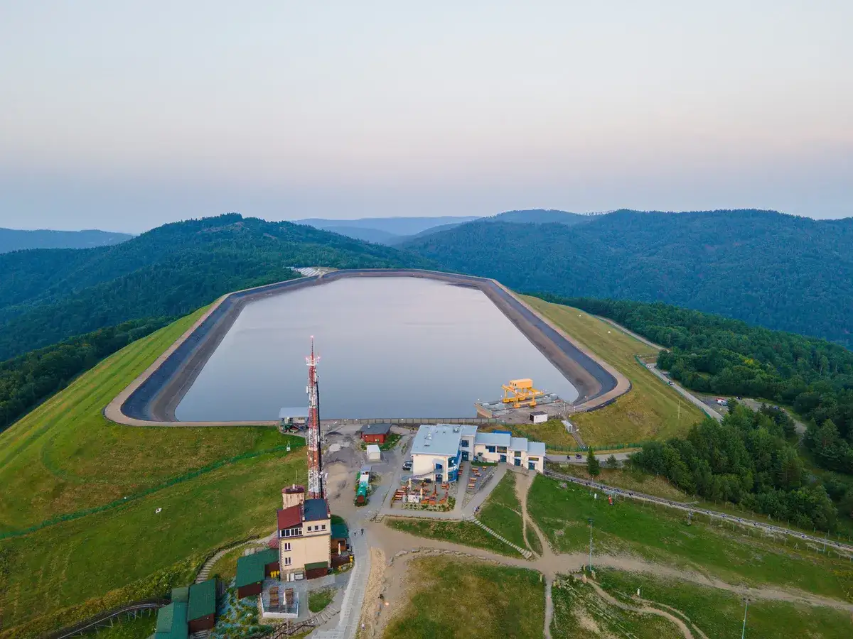 Zbiornik na szczycie góry Żar, otoczony lasami, z budynkami i wieżą telekomunikacyjną.