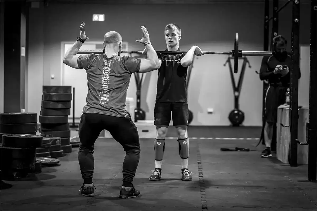 Grupa ludzi trenujących CrossFit w boxie