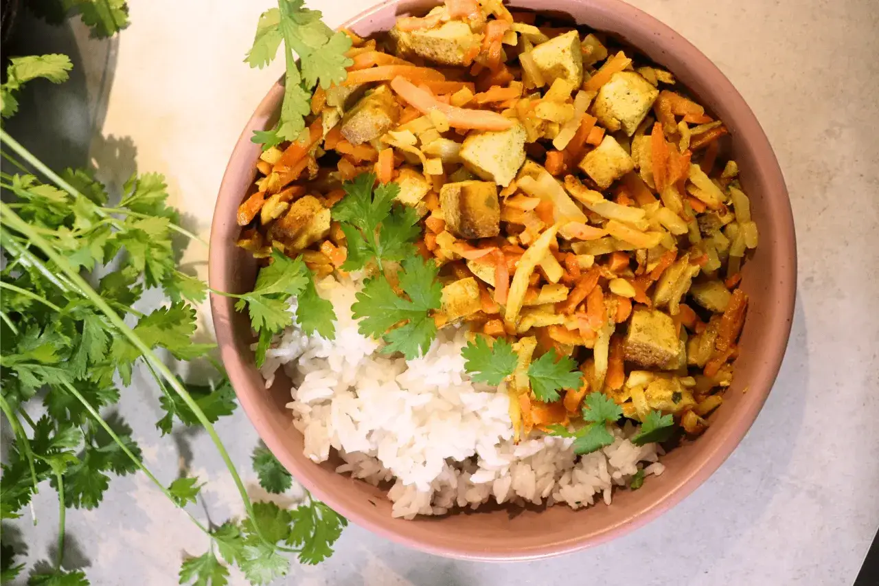 Pyszne danie co na obiad bez mięsa: ryż z warzywami i tofu, posypane świeżą kolendrą.