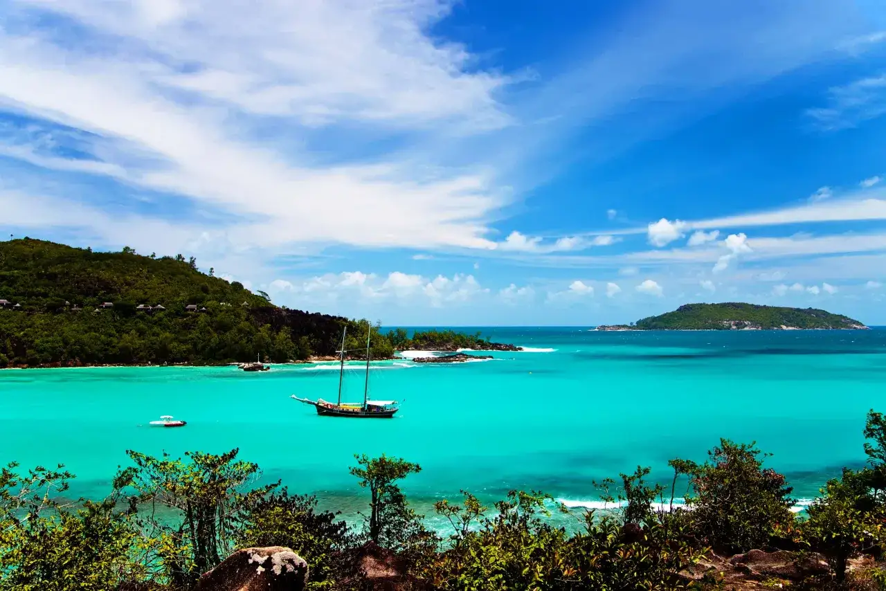 Turkusowa woda, zielone wzg&oacute;rza i żaglowiec. Marzysz o podr&oacute;ży na Seszele? Sprawdź, ile trwa lot!