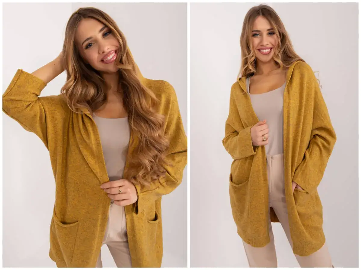 Uśmiechnięta kobieta w musztardowym kardiganie z kapturem i kieszeniami. To idealny kardigan co to za styl!