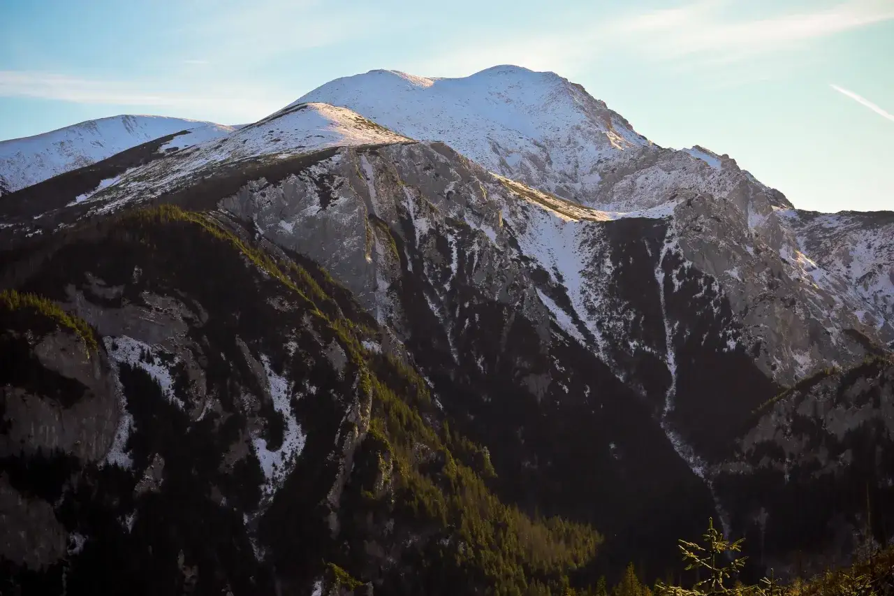 Zimowe szlaki w Tatrach Zachodnich, ośnieżone szczyty i ciemne lasy. Idealne miejsce na zimowe wędr&oacute;wki z Zakopanego.