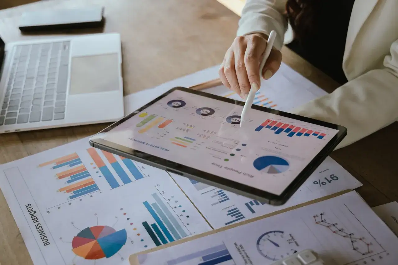 Kobieta analizuje wykresy na tablecie, co świadczy o jej zaangażowaniu w kontrolę proces&oacute;w biznesowych.
