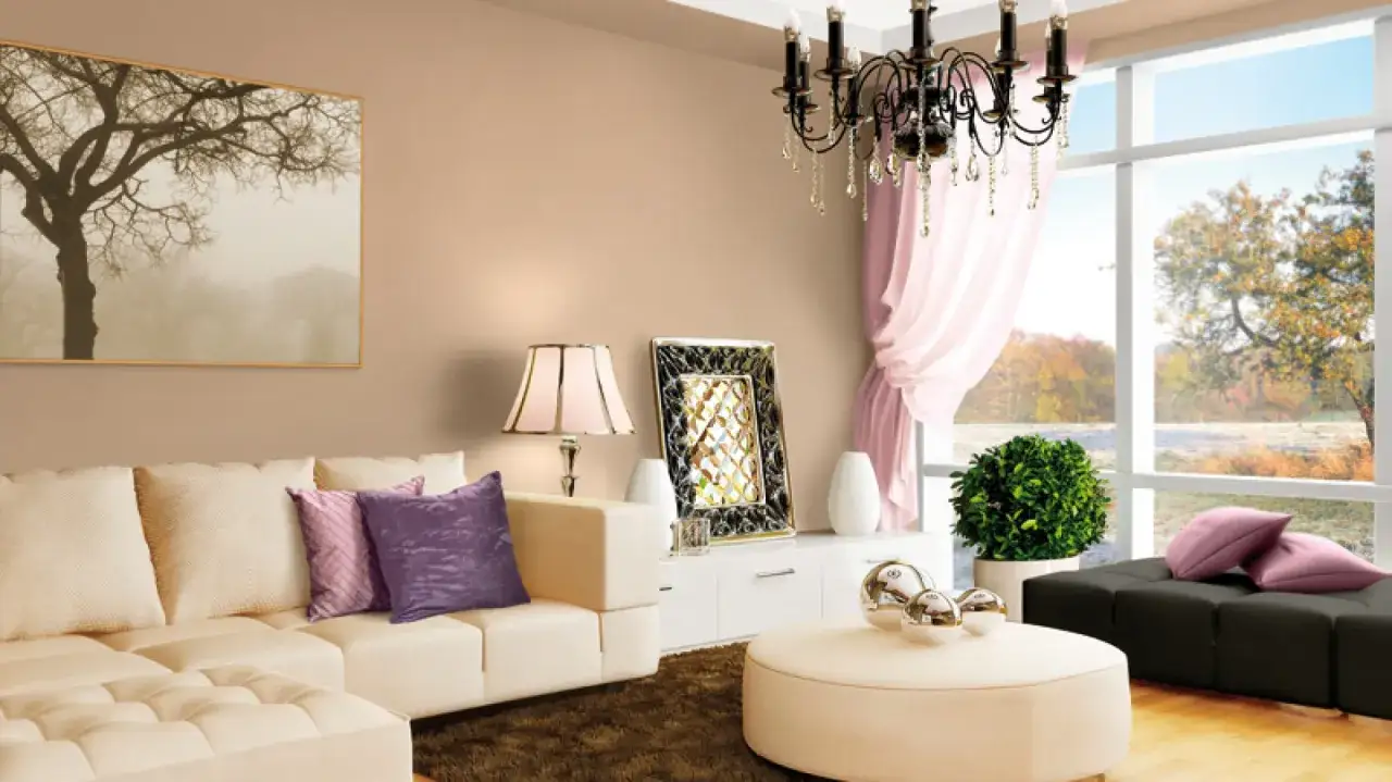 Elegancki salon z kremową kanapą, fioletowymi poduszkami i obrazem drzewa. Inspirujące kolory do salonu.