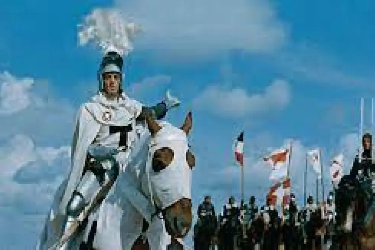 Rycerz w zbroi na koniu, w tle flagi i inni jeźdźcy. Scena przypomina, gdzie kręcono Krzyżaków.