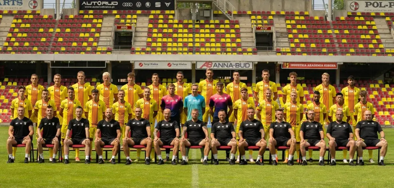 Drużyna Korona Kielce zawodnicy pozują do zdjęcia na tle stadionu.