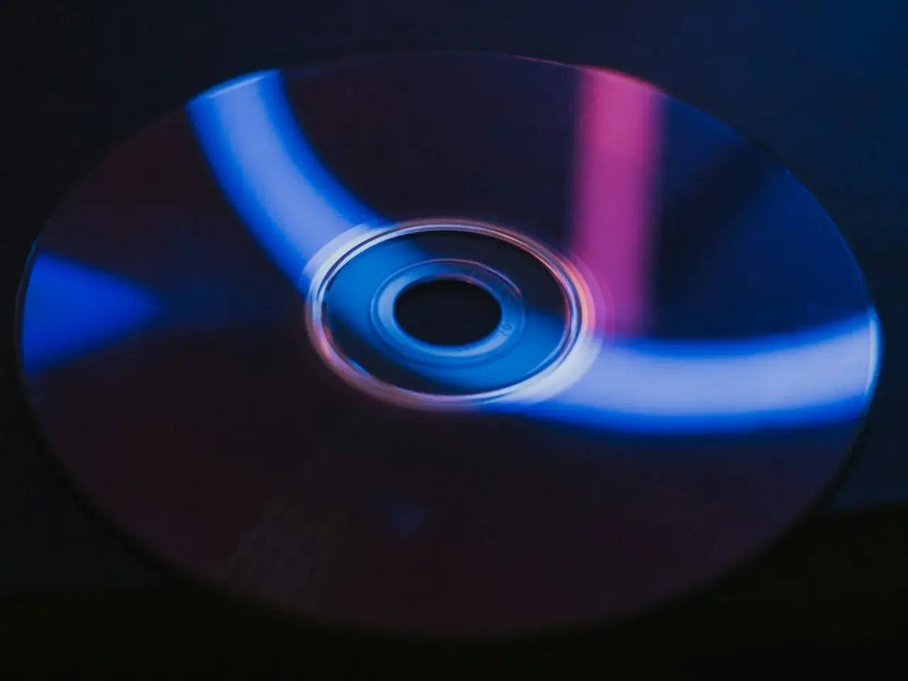Płyta CD z niebieskimi i różowymi refleksami. Zastanawiasz się, płyty CD gdzie wyrzucić?