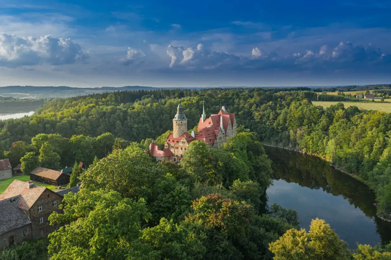 Zamek Książ, jedna z największych atrakcji Dolnego Śląska, otoczony bujną zielenią i malowniczą rzeką.