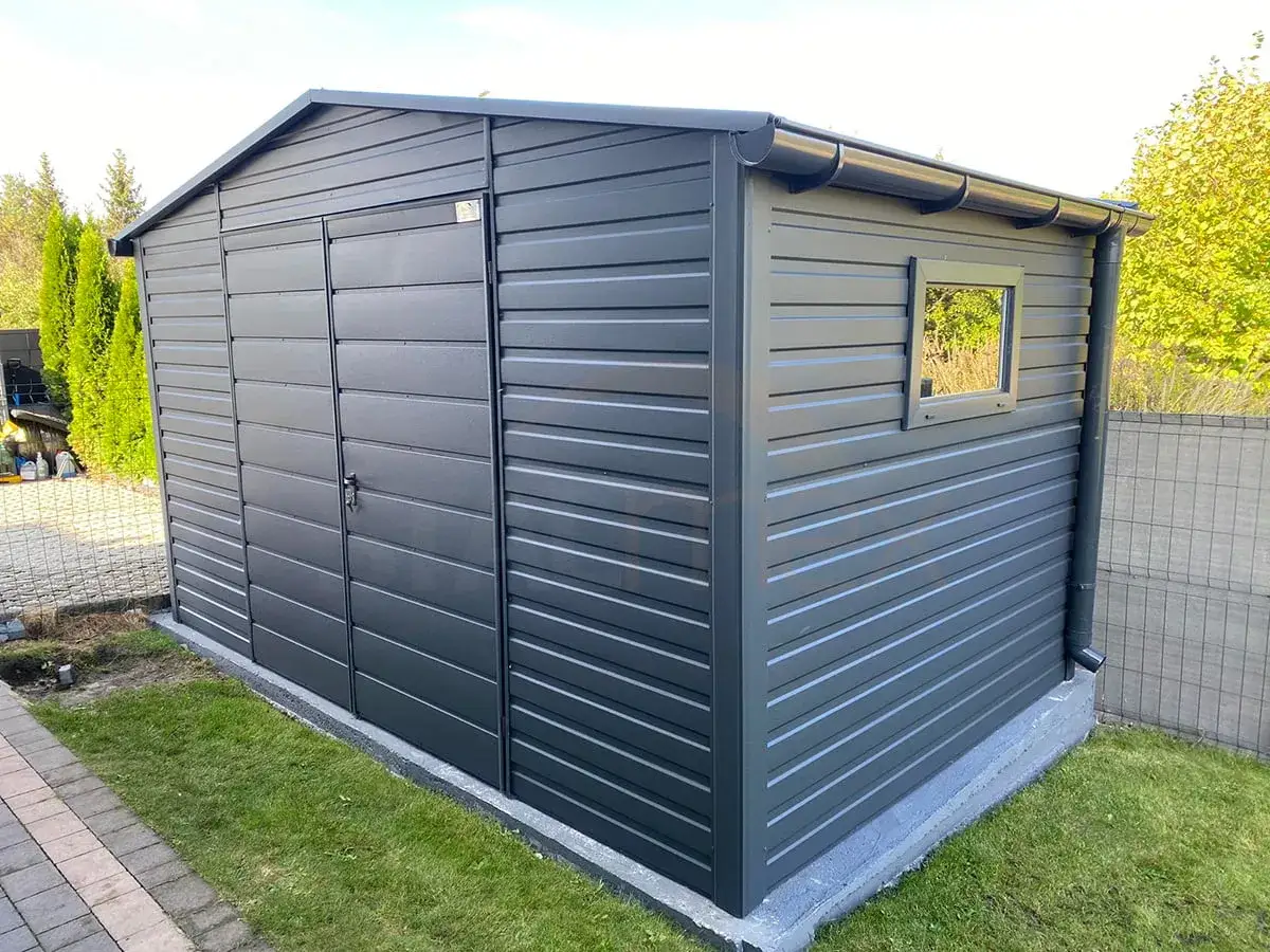 Nowoczesny, ciemnoszary domek narzędziowy z drzwiami i małym oknem. Zastanawiasz się, czy domek narzędziowy trzeba zgłaszać?