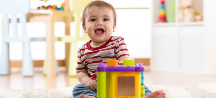 szczęśliwe niemowlę bawiące się zabawkami