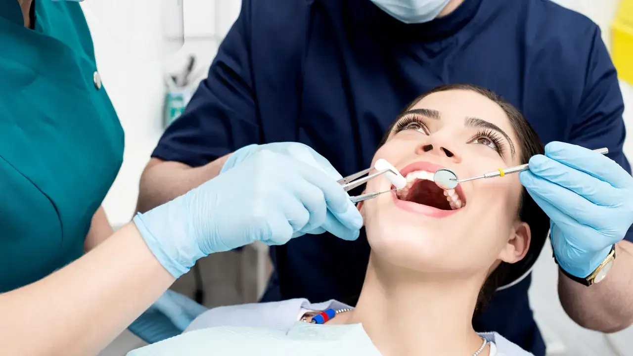 osoba z zimnym okładem na policzku po wizycie u dentysty