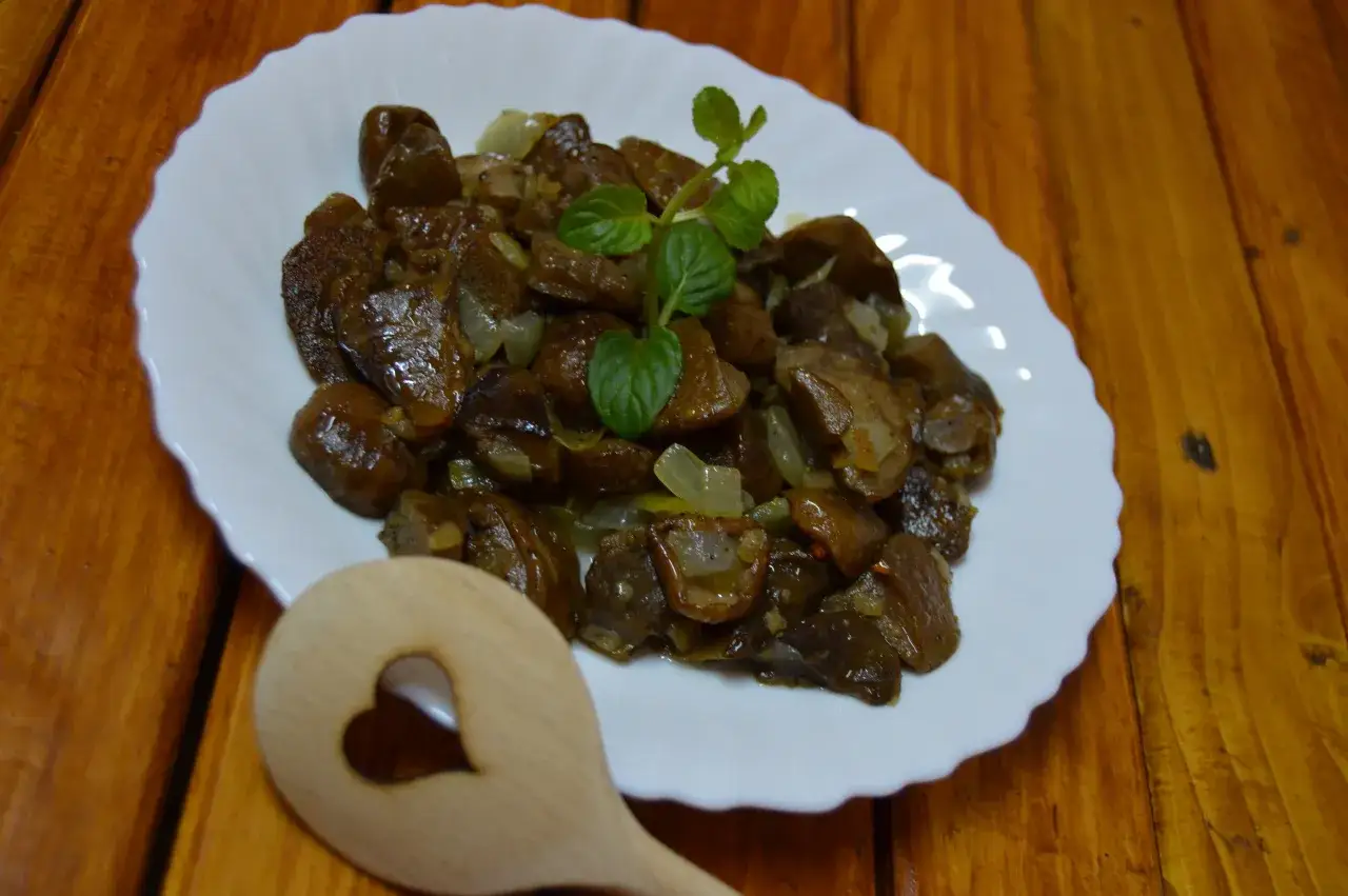 Smażone grzyby z cebulką na talerzu. Odpowiedź na pytanie: czy mrożone grzyby można wrzucić na patelnię? Tak, można!