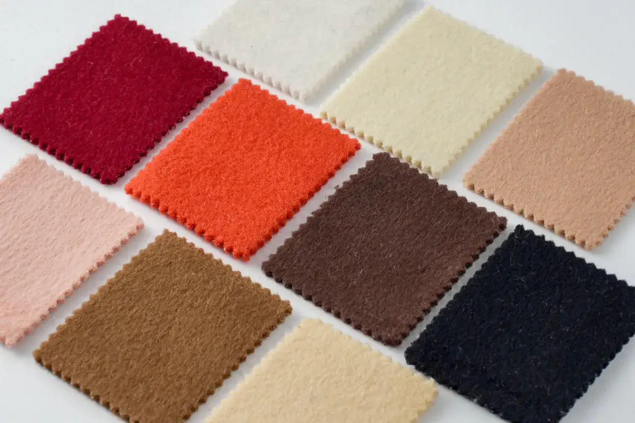 Pr&oacute;bki filcu w r&oacute;żnych kolorach: czerwony, pomarańczowy, r&oacute;żowy, brązowy, czarny, beżowy, kremowy. Akryl to materiał, z kt&oacute;rego wykonano te pr&oacute;bki.