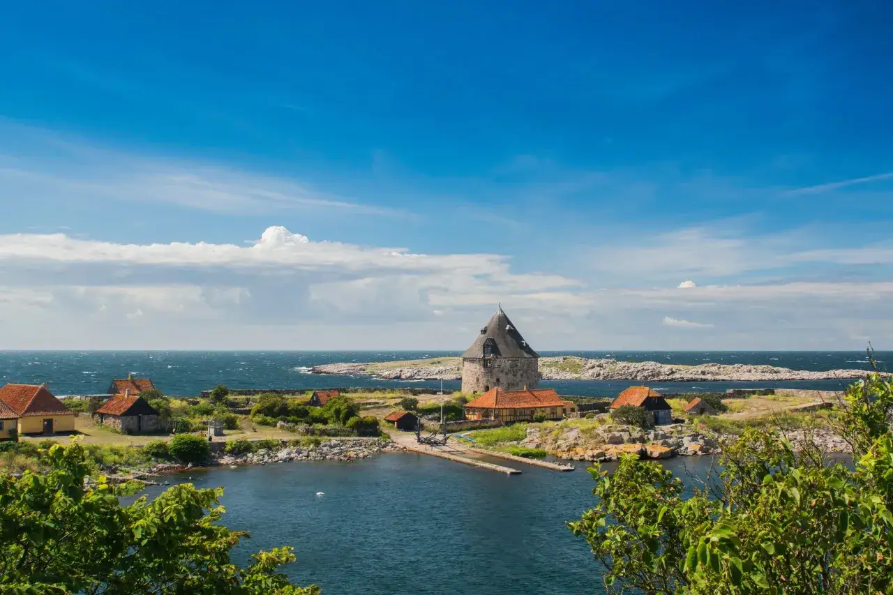 Kamienna wieża i domy z czerwonymi dachami na duńskiej wyspie na Bałtyku.