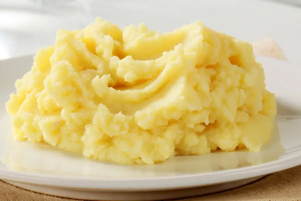 Puszyste, kremowe puree ziemniaczane na białym talerzu. Idealne, gdy zastanawiasz się, ile gotować ziemniaki, by uzyskać taki efekt.